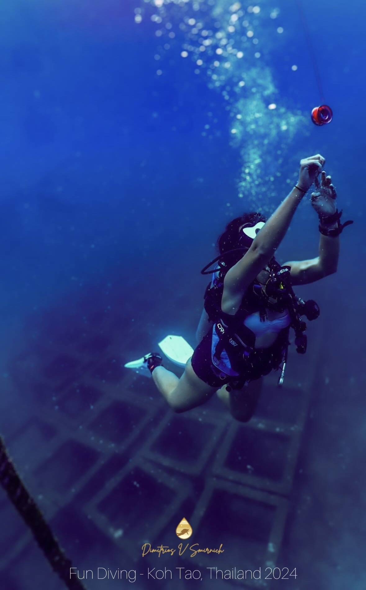 Divemaster deploying a surface marker buoy while diving in Koh Tao, Thailand